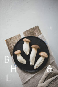 Mushrooms on a black plate on a wooden bench