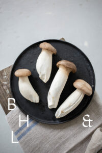 Mushrooms on a black plate on a wooden bench