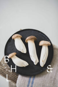 Mushrooms on a black plate on a wooden bench