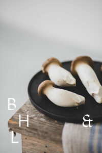 Mushrooms on a black plate on a wooden bench