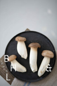 Mushrooms on a black plate on a wooden bench