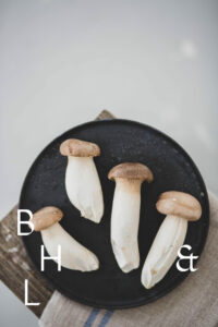 Mushrooms on a black plate on a wooden bench