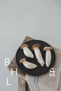 Mushrooms on a black plate on a wooden bench