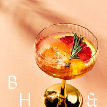 Closeup of summer cocktails and drinks with blood orange and rosemary on coral background