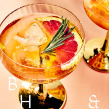 Closeup of summer cocktails and drinks with blood orange and rosemary on coral background