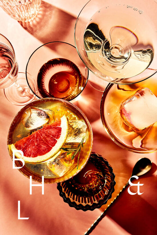 Summer cocktails with blood orange and grapefruit on coral background tabletop