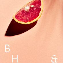 A slice of grapefruit on coral background
