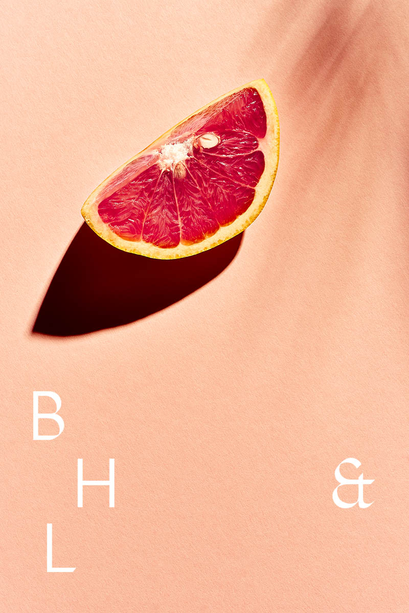 A slice of grapefruit on coral background