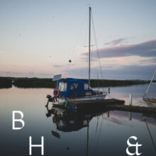 Travel photography of a lake in Poland with a boat and reflections on the water in the morning light