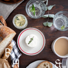 Food photography of a house boat in Poland with a top shot from the table with goat cheese, bread, coffee and herb buttere
