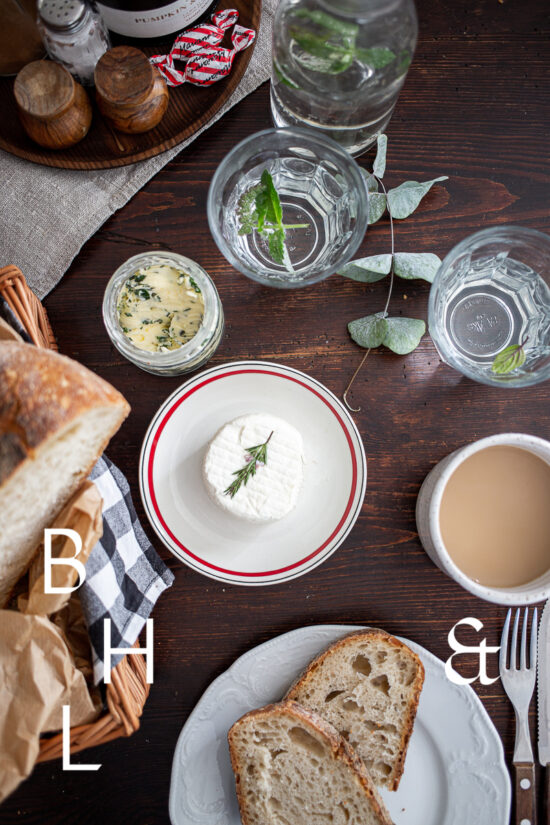 Food photography of a house boat in Poland with a top shot from the table with goat cheese, bread, coffee and herb buttere