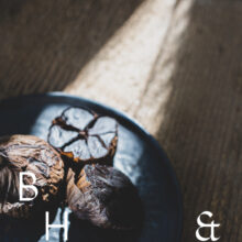 Food photography of black garlic on a black plate cut open