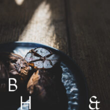 Food photography of black garlic on a black plate cut open