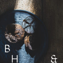 Food photography of black garlic on a black plate cut open