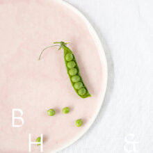 Food photography of a pea pod on a pastel plate on white table clove from above