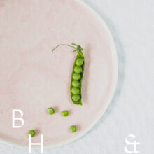 Food photography of a pea pod on a pastel plate on white table clove from above