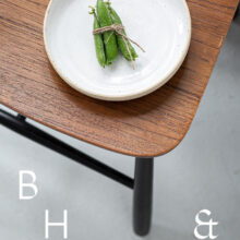 Food photography of a pea pod on a white plate on a wooden chair from above