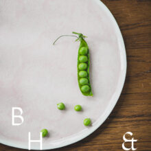 Food photography of a pea pod on a pastel plate on a wooden table from above