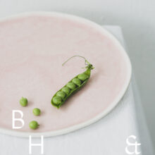 Food photography of a pea pod on a pastel plate on white table clove