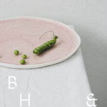 Food photography of a pea pod on a pastel plate on white table clove
