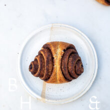 Food photography of cinnamon rolls on a white plate on light marble