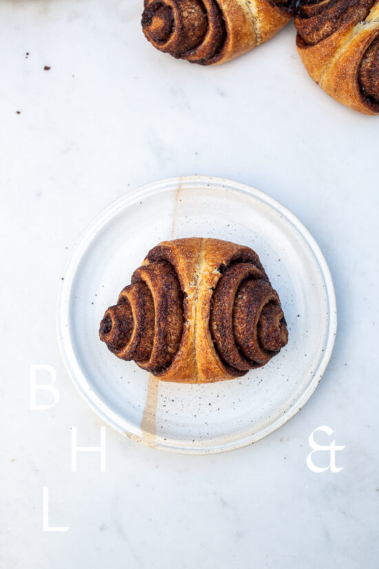 Food photography of cinnamon rolls on a white plate on light marble