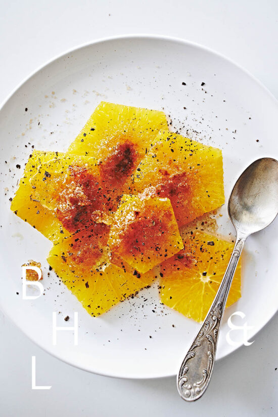 Food photography of caramelized oranges with cinnamon flower