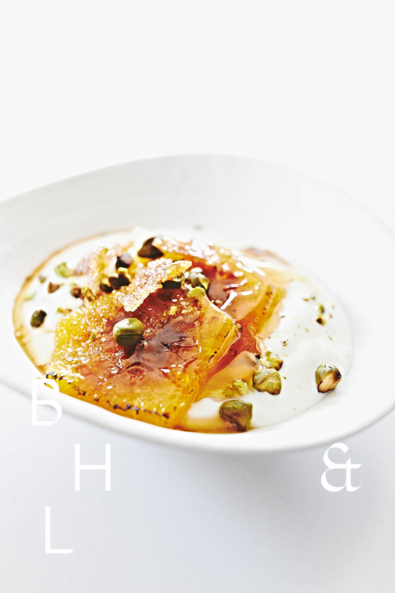 Greek yoghurt with caramelized oranges and pistacchios as dessert - food photography