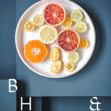 Food photography of citrus fruit on a white plate on blue ground