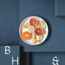 Food photography of citrus fruit on a white plate on blue ground