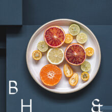 Food photography of citrus fruit on a white plate on blue ground
