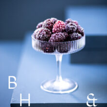 Food photography of frozen blackberries in a frozen glas on a blue background