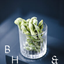 Food photography of frozen edamame in a frozen glas on a dark blue background