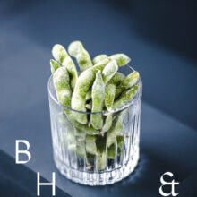 Food photography of frozen edamame in a frozen glas on a dark blue background