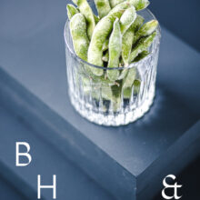 Food photography of frozen edamame in a frozen glas on a dark blue background