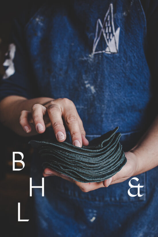 Food photography and food reportage about Maizajo and a dark tortilla stack in the hands of a worker